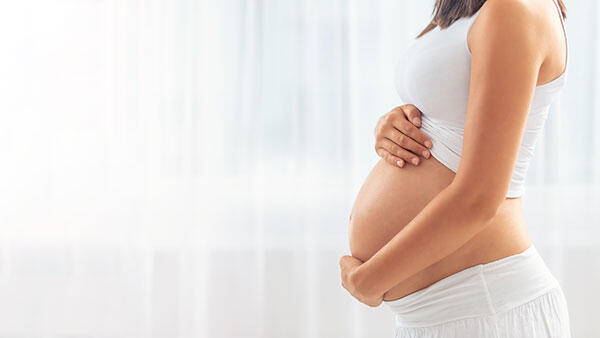 Schwangere Ärztin hält ihren Bauch